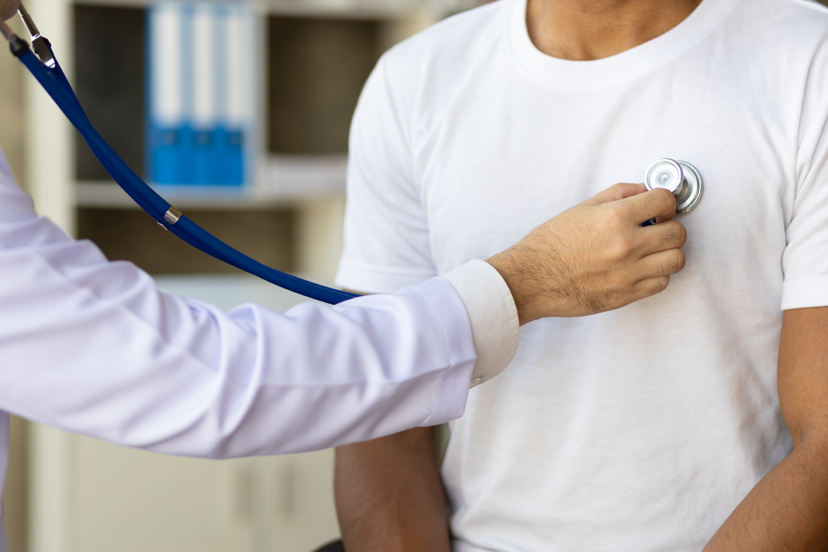 Médico cardiologista com o estetoscópio fazendo ausculta com o paciente.
